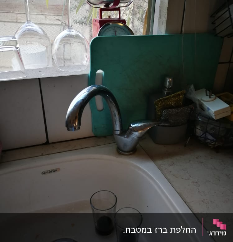 ברז מטבח עם כיור וכוסות על השיש